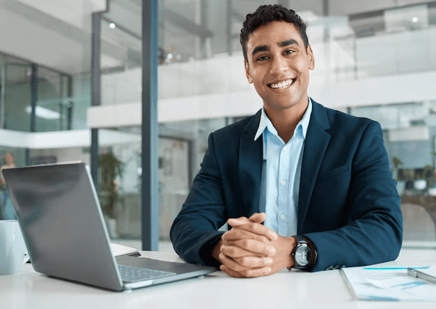 Professional businessman smiling at desk with laptop in modern office enjoying Best personal finance tools